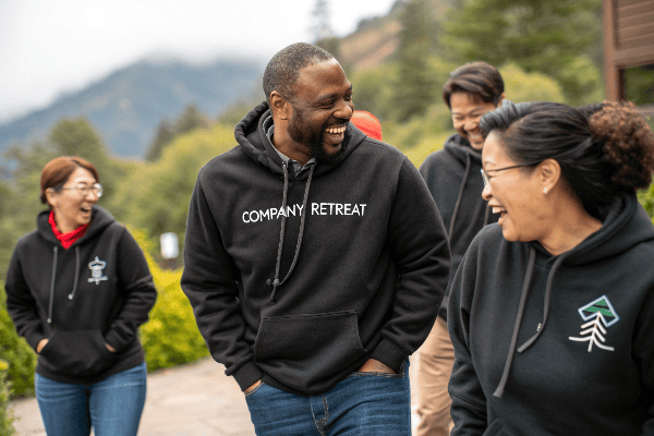 Diverse group wearing matching branded hoodies at company event