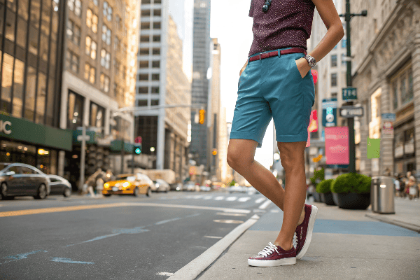 Stylish person wearing Bermuda shorts with urban background